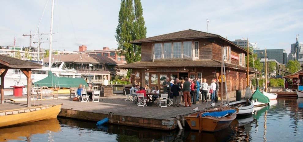 People gathered for a party on a deck at a floating house.