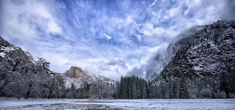 Mountain landscape photograph with snow covered mountains and blue sky.