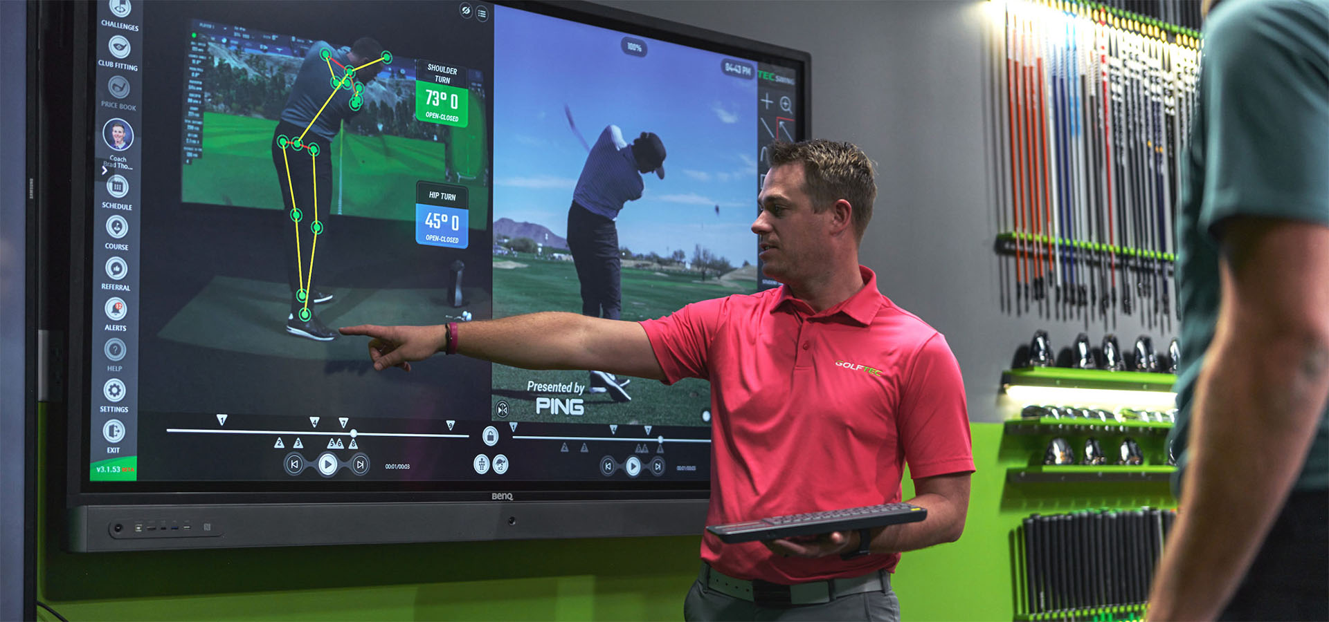golf instructor showing something on screen to student