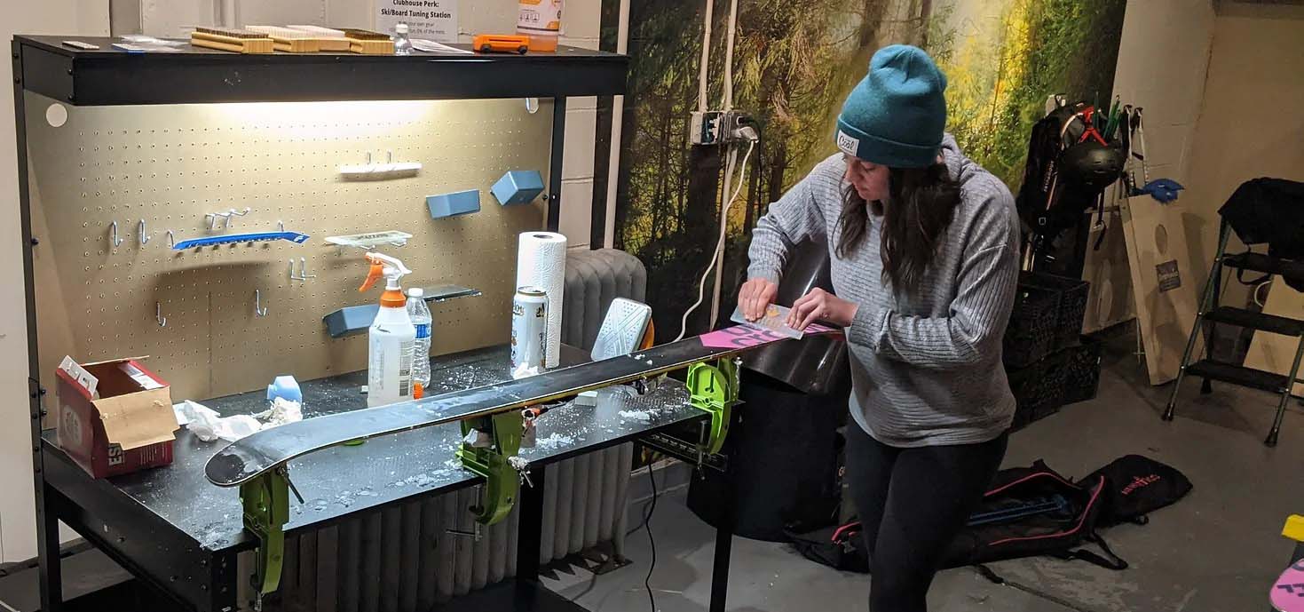 Woman waxing her skis.