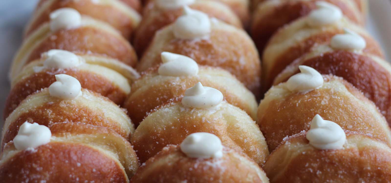 Rows of custard filled donuts.