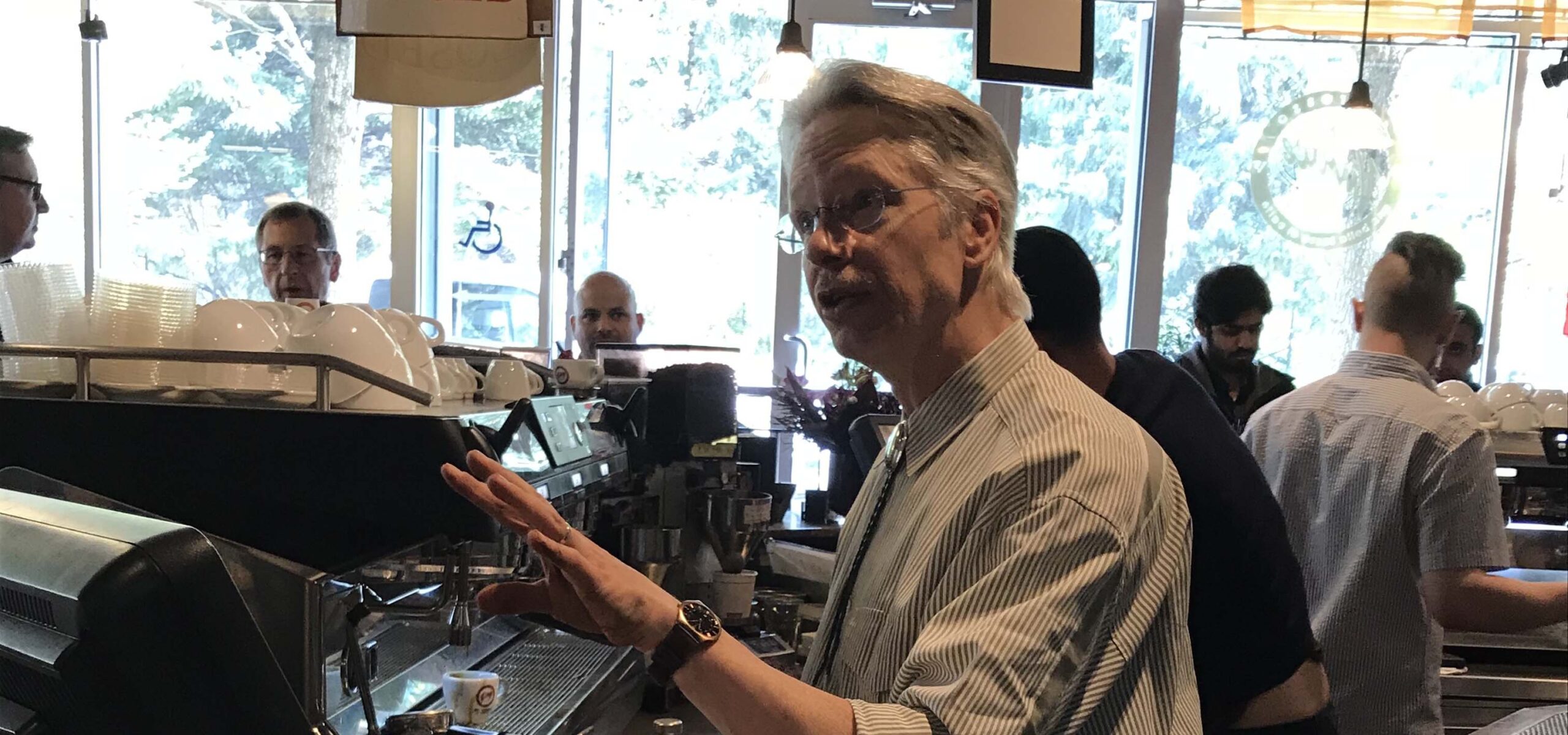 Man talking behind a coffee machine.