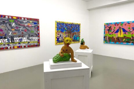 Inside an art exhibit with paintings and sculptures.