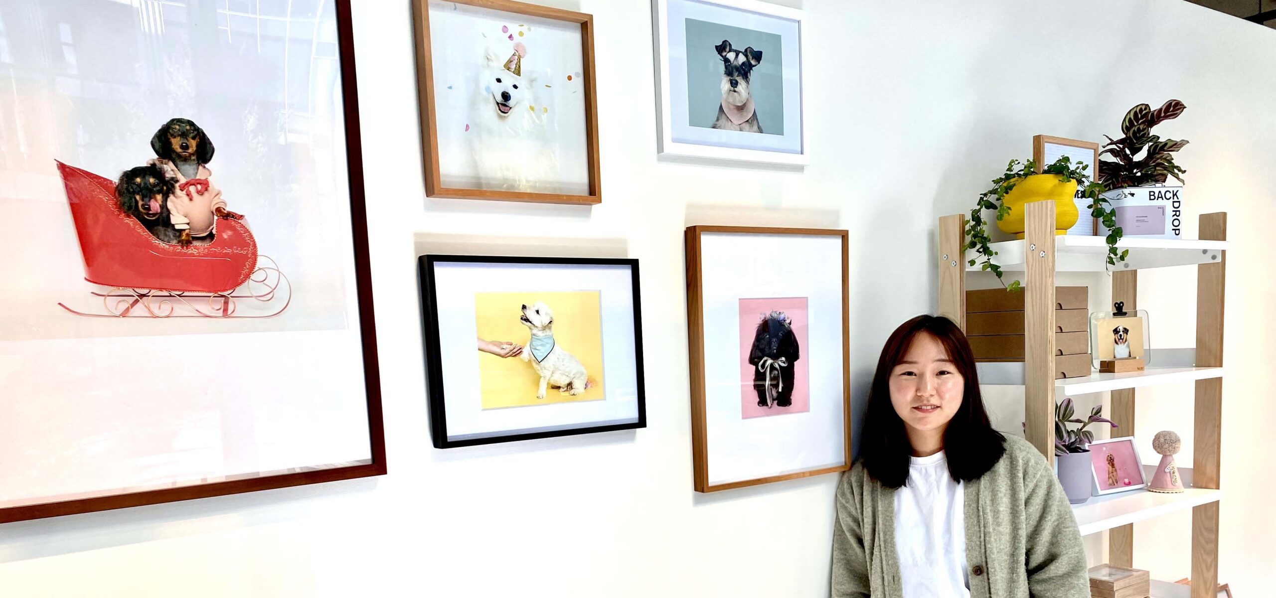 Woman standing by photos of dogs.