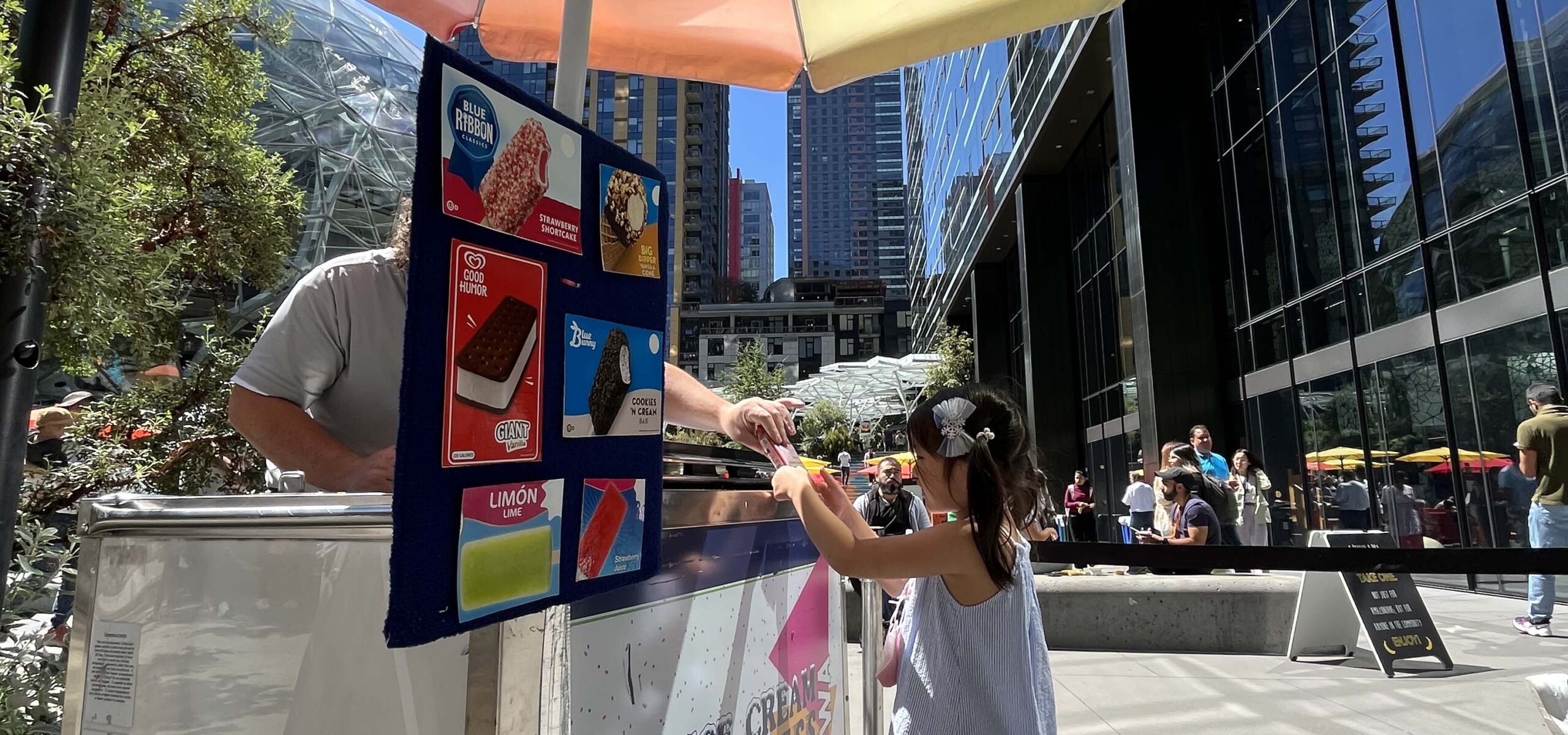 Girl buying ice cream from a cart vendor.