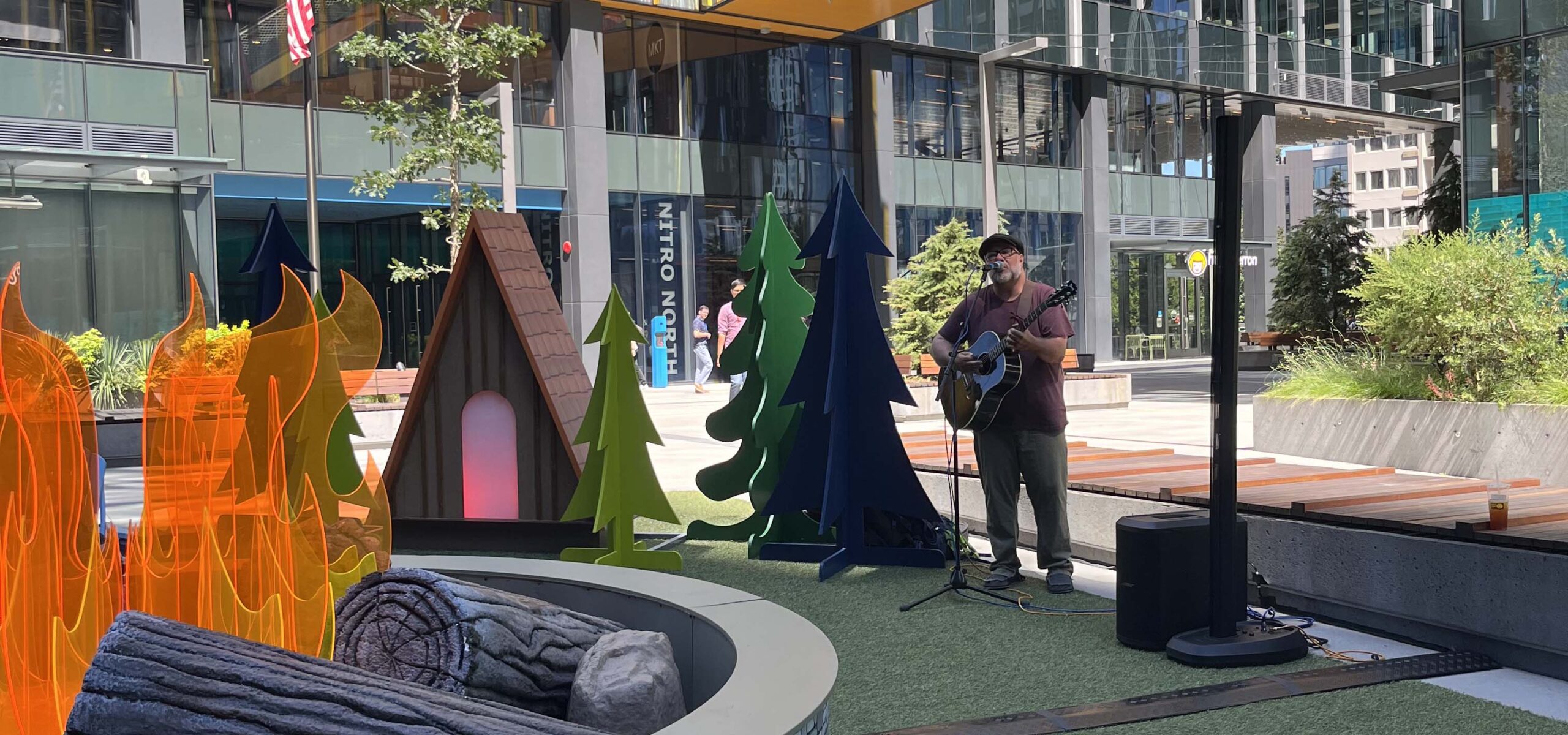 Guitarist playing in a business courtyard.