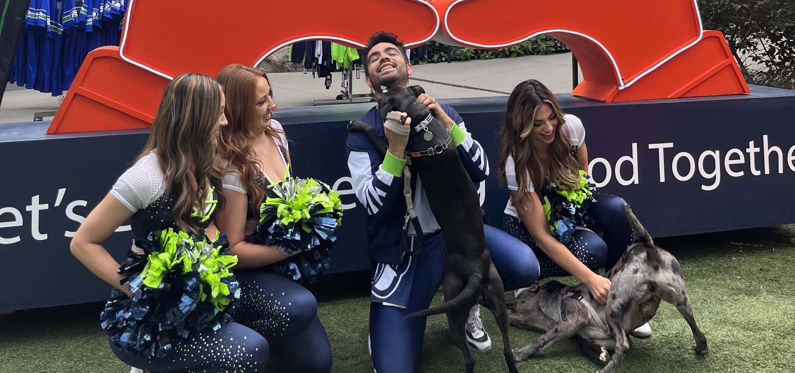 Cheerleaders playing with dogs.