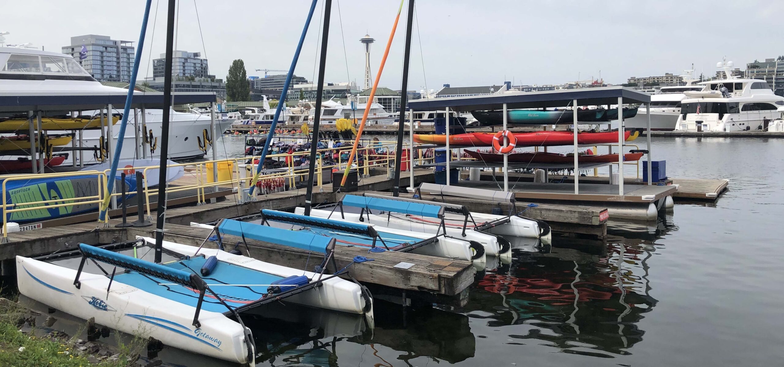 Boat slip with several kayaks, stand up paddle boards, and other small boats.