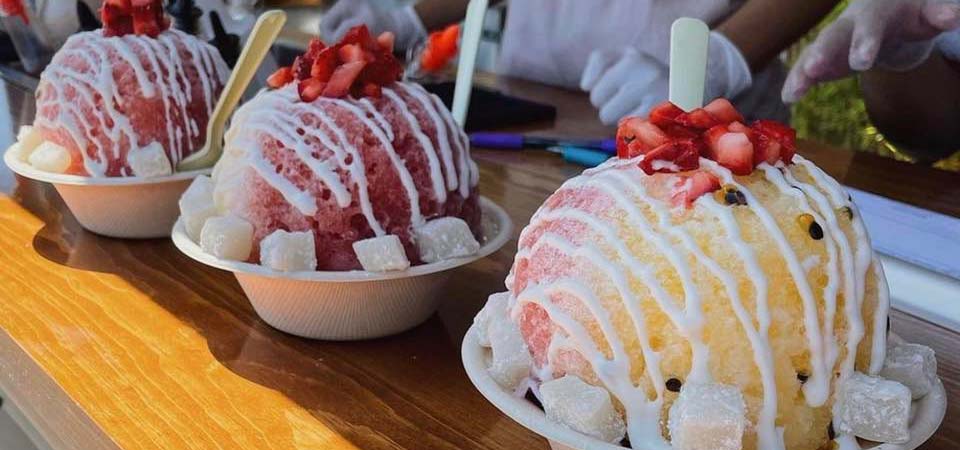 Photo of shave ice treats topped with strawberry and mochi.