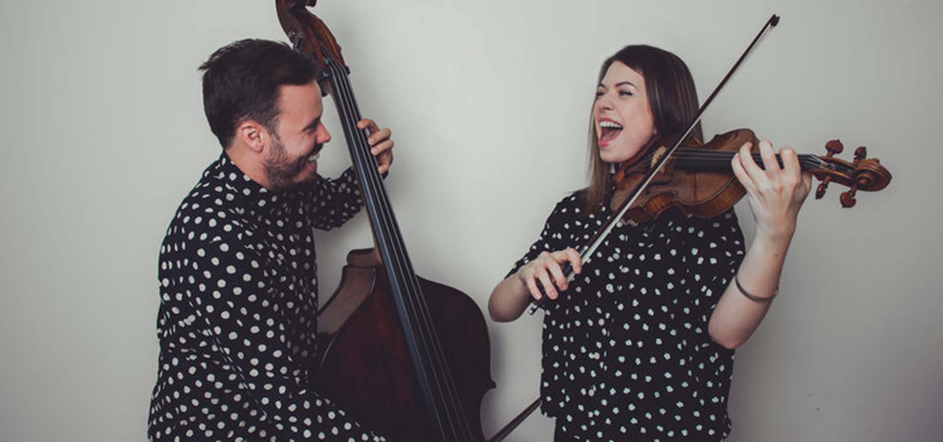 A man and women playing a cello and violin