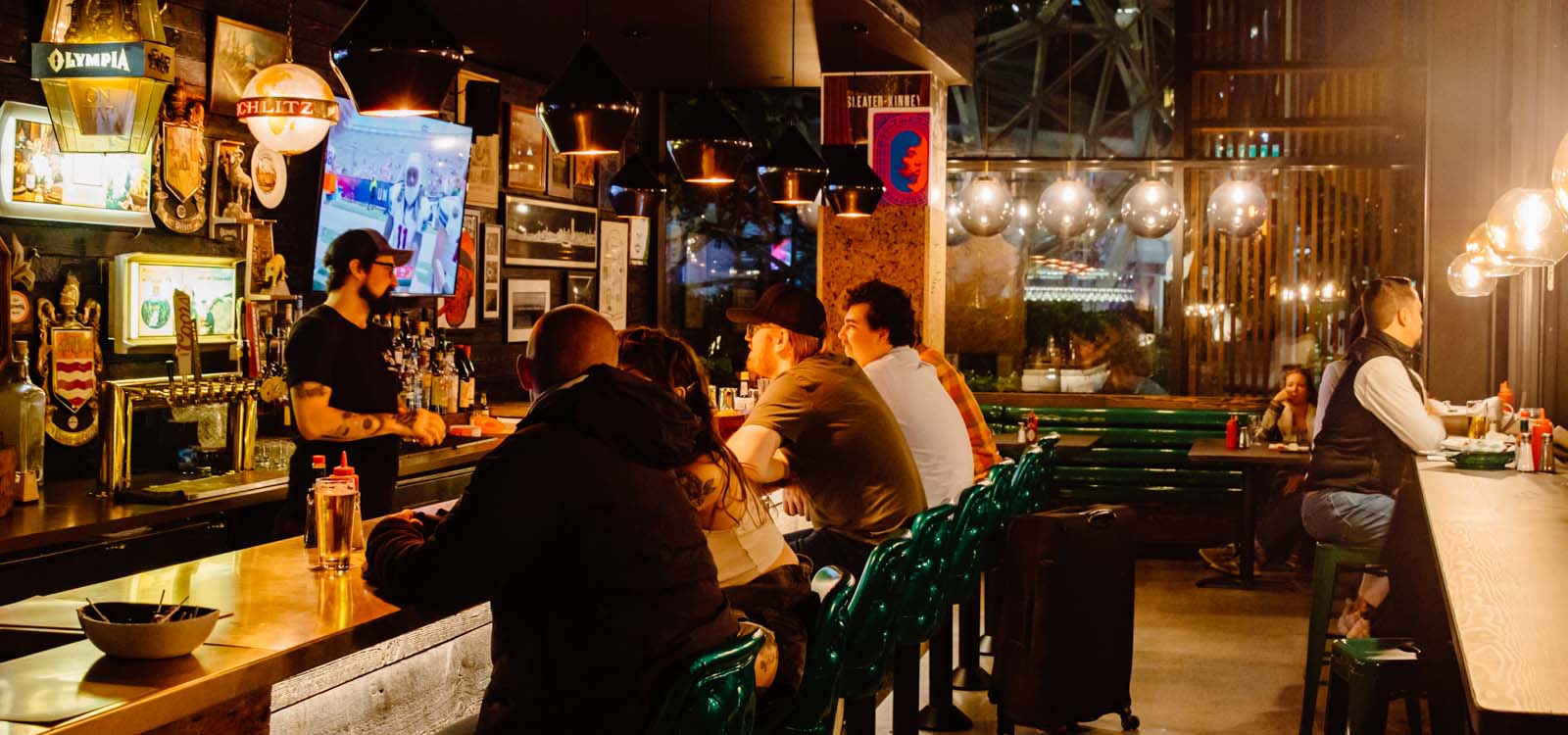 People sitting and drinking at a bar in the evening.