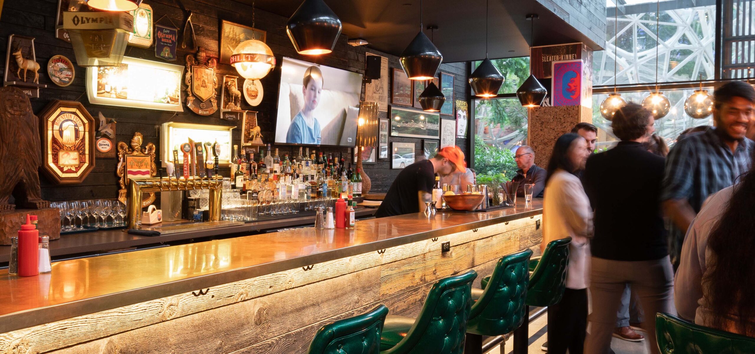 People hanging out in a sports bar with a game on.