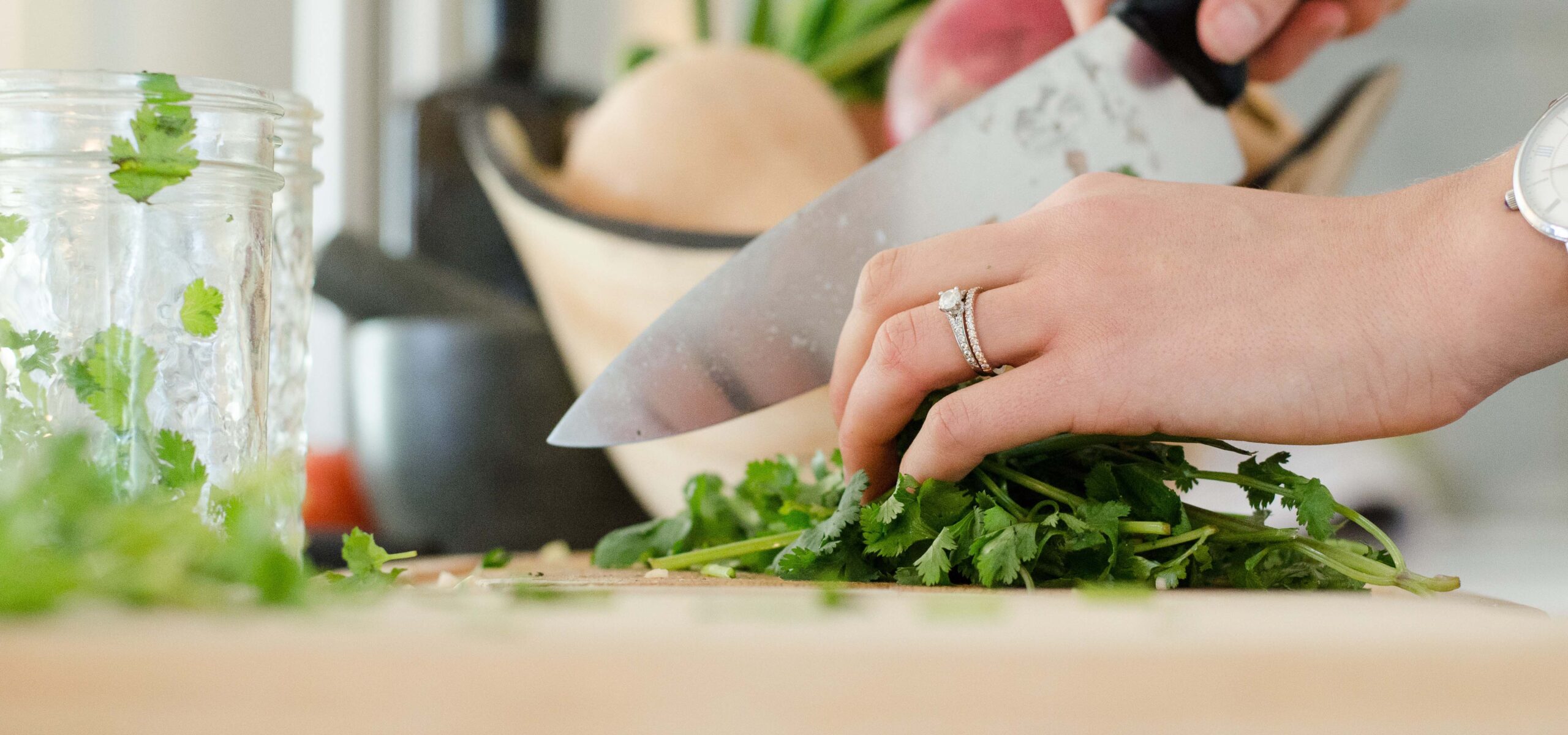 Woman's hand chopping herbs.