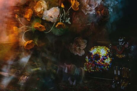 Dark painting of mixed media and flowers.