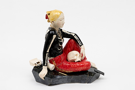 sculpture of sitting woman with skull