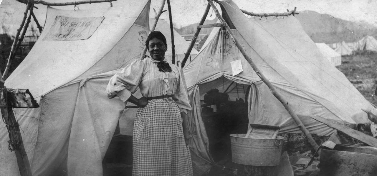 Woman posing in front of a tent.