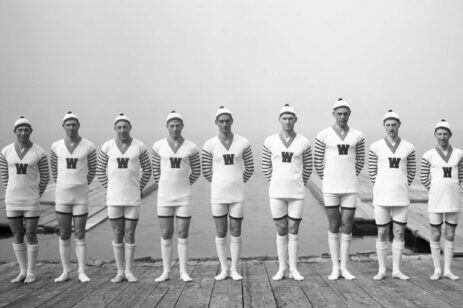 Old photo of a rowing team on a pier.