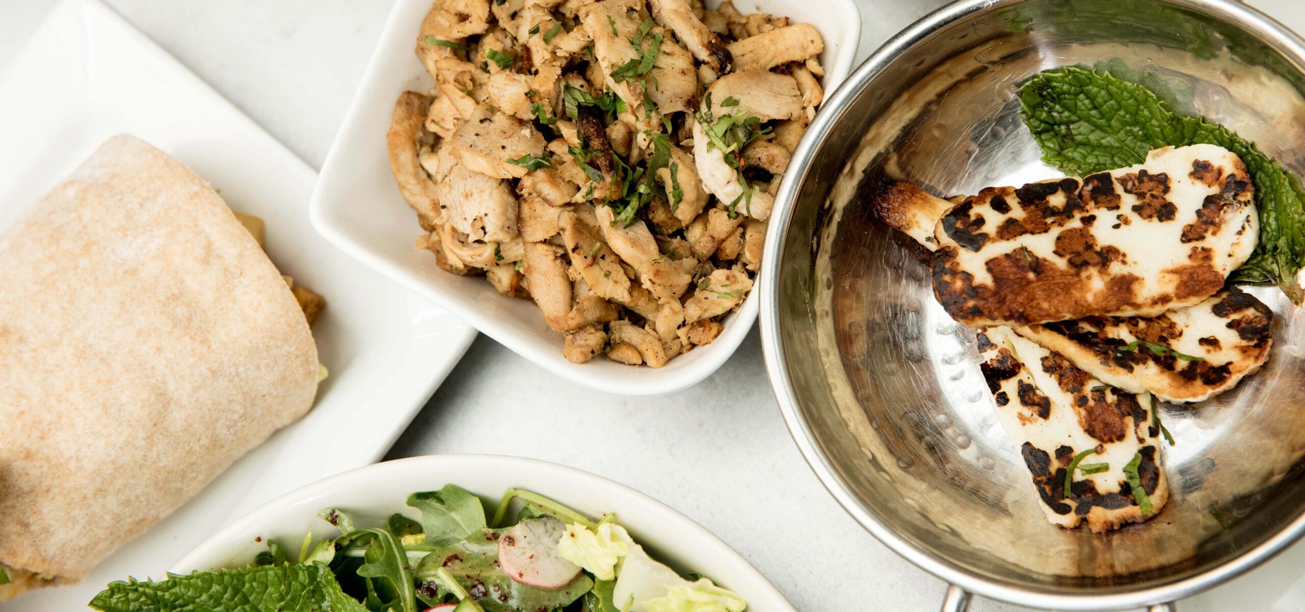 Array of middle eastern dishes on a table top.