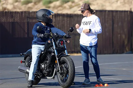 woman teaching someone to ride motorcycle