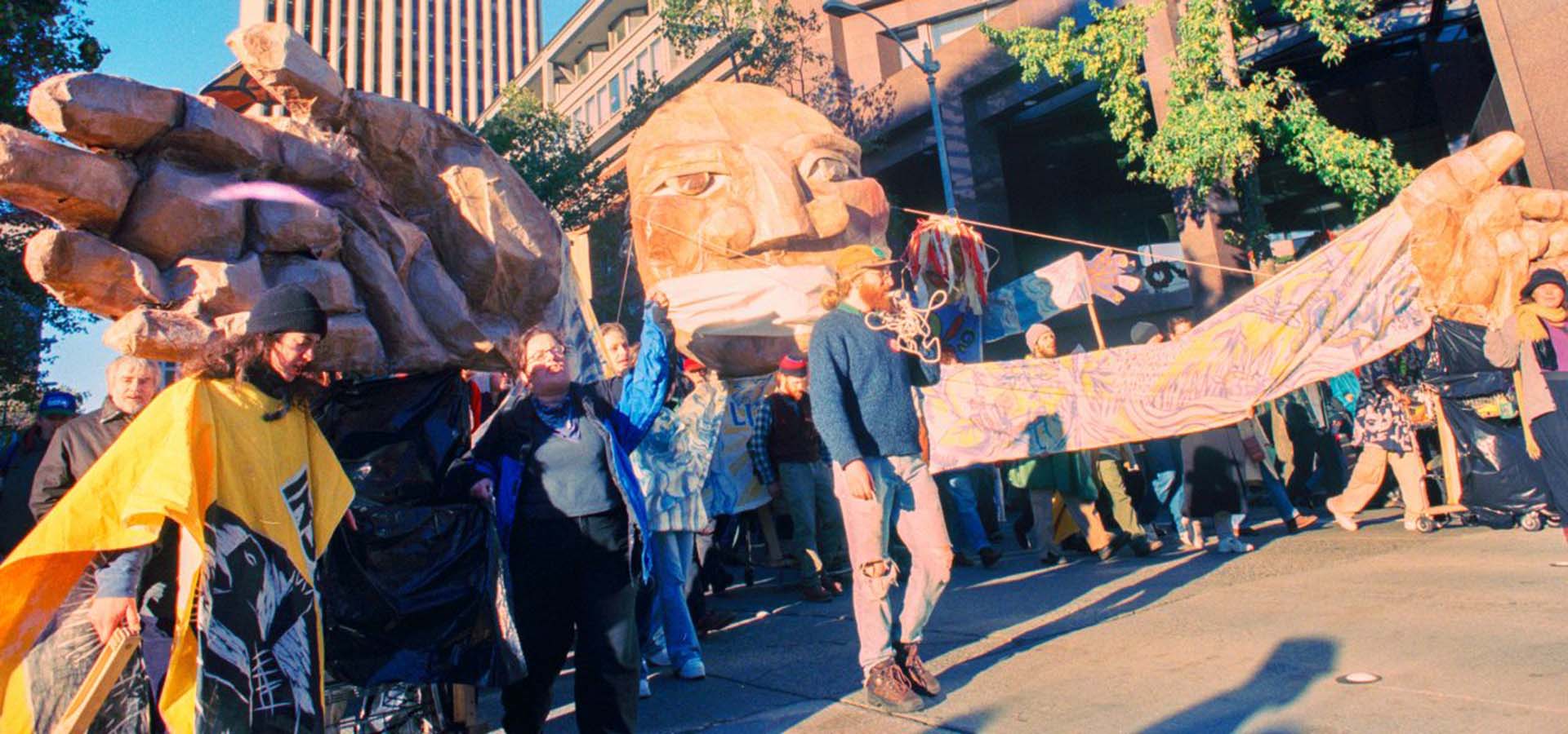 Protesters in the streets with bullhorn, signs, and floats