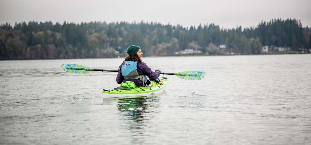 A woman kayaking on a lake.