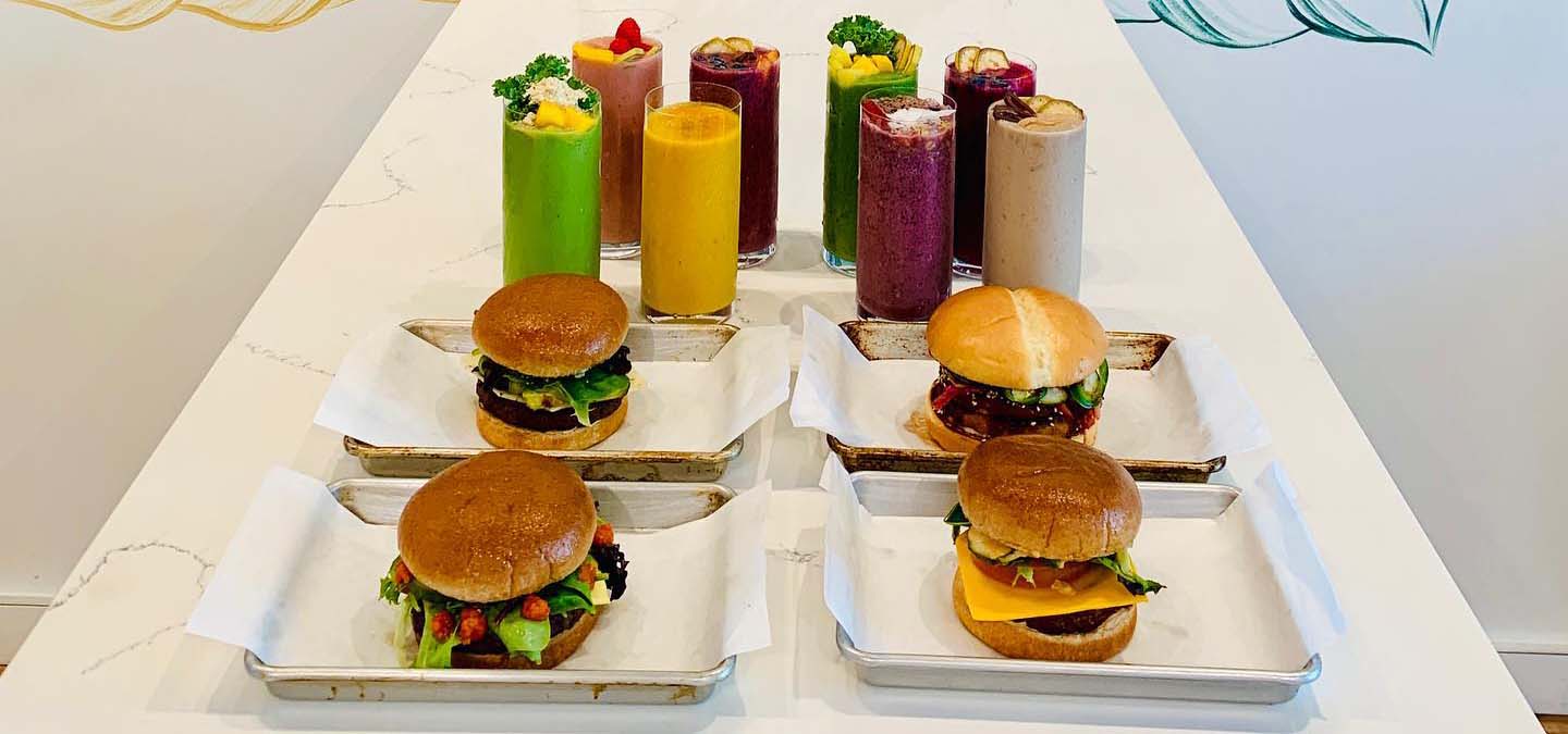 Table spread of plant-based burgers and smoothies.