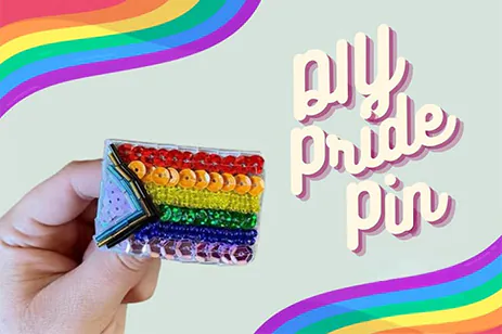 hand holding sequined pride flag pin