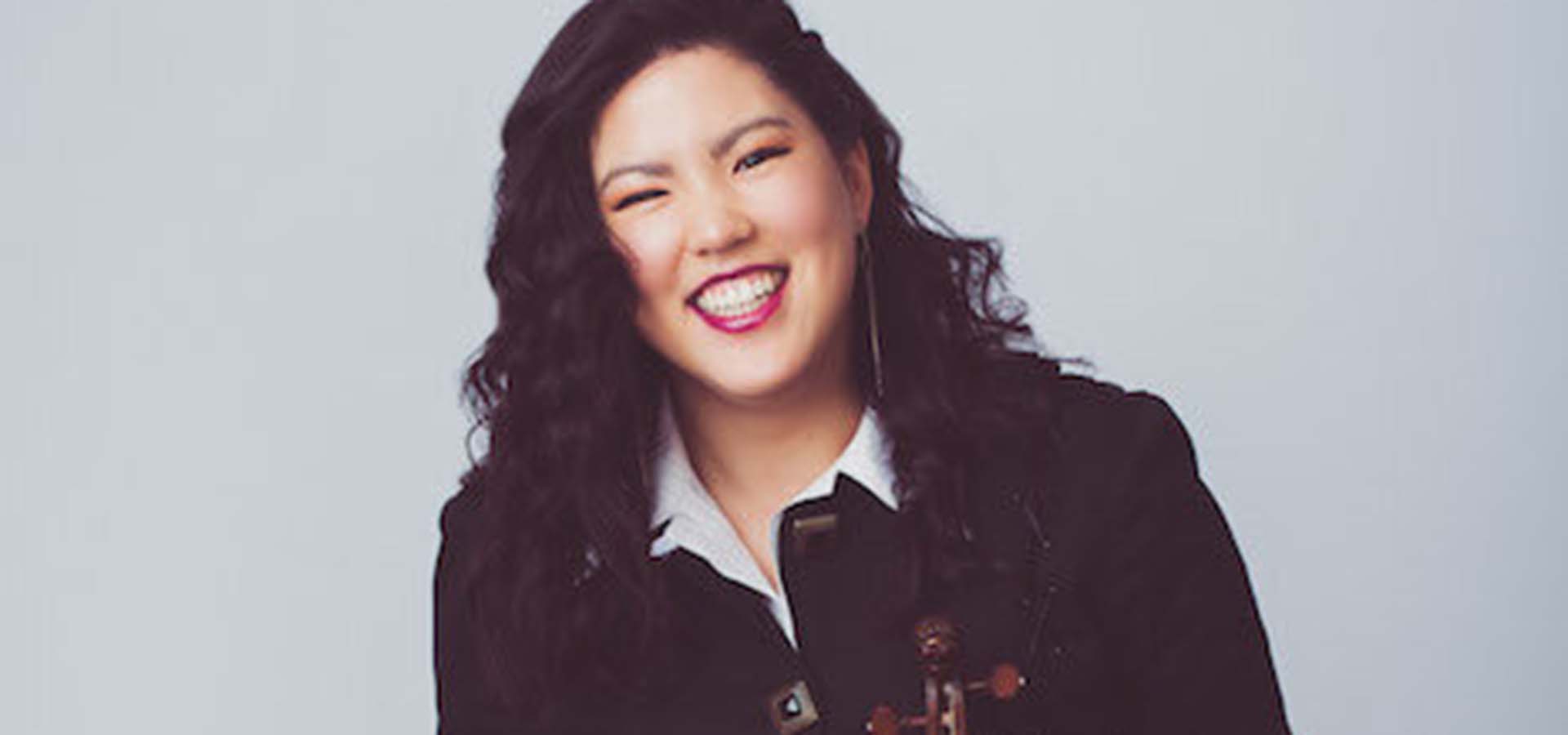 Asian women smiling and holding a violin