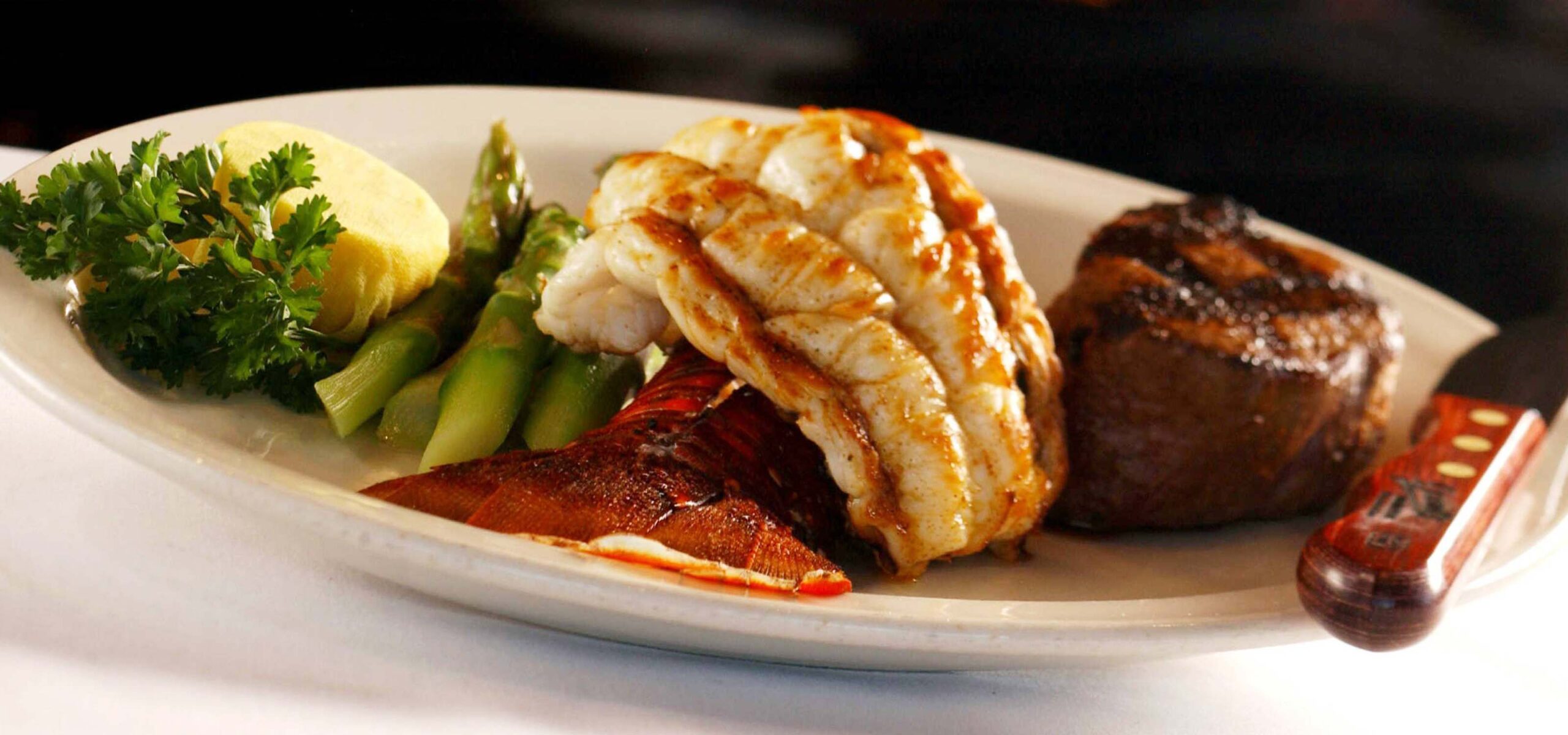 Surf and turf plated meal in front of a fireplace.