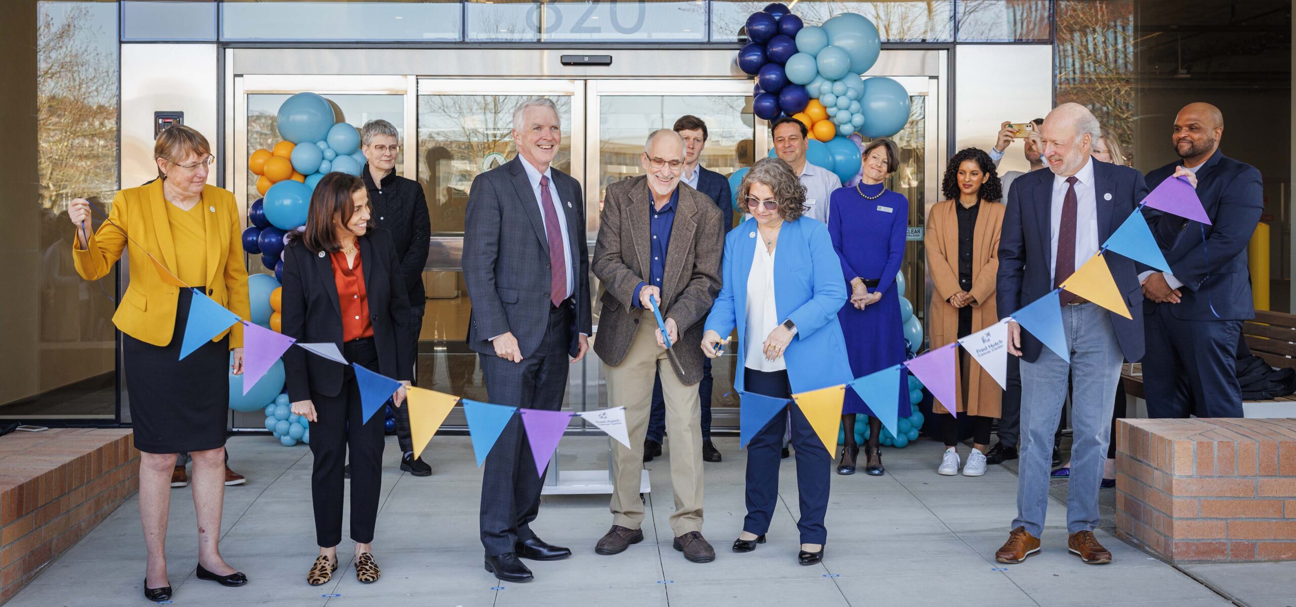 A group of people doing a grand opening ribbon cutting ceremony.