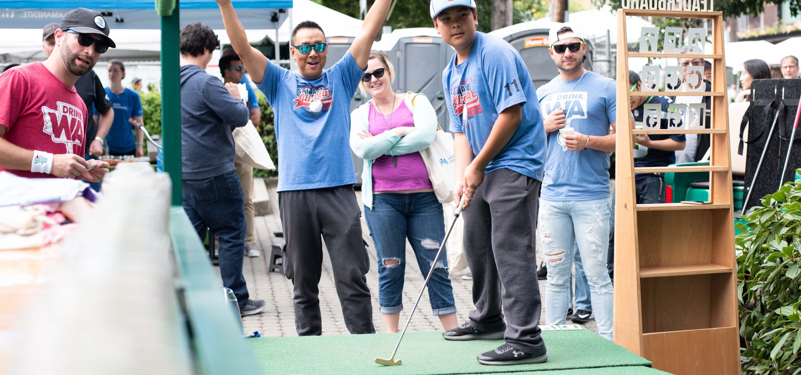 People watching a man putt putt at SLU Block Party.