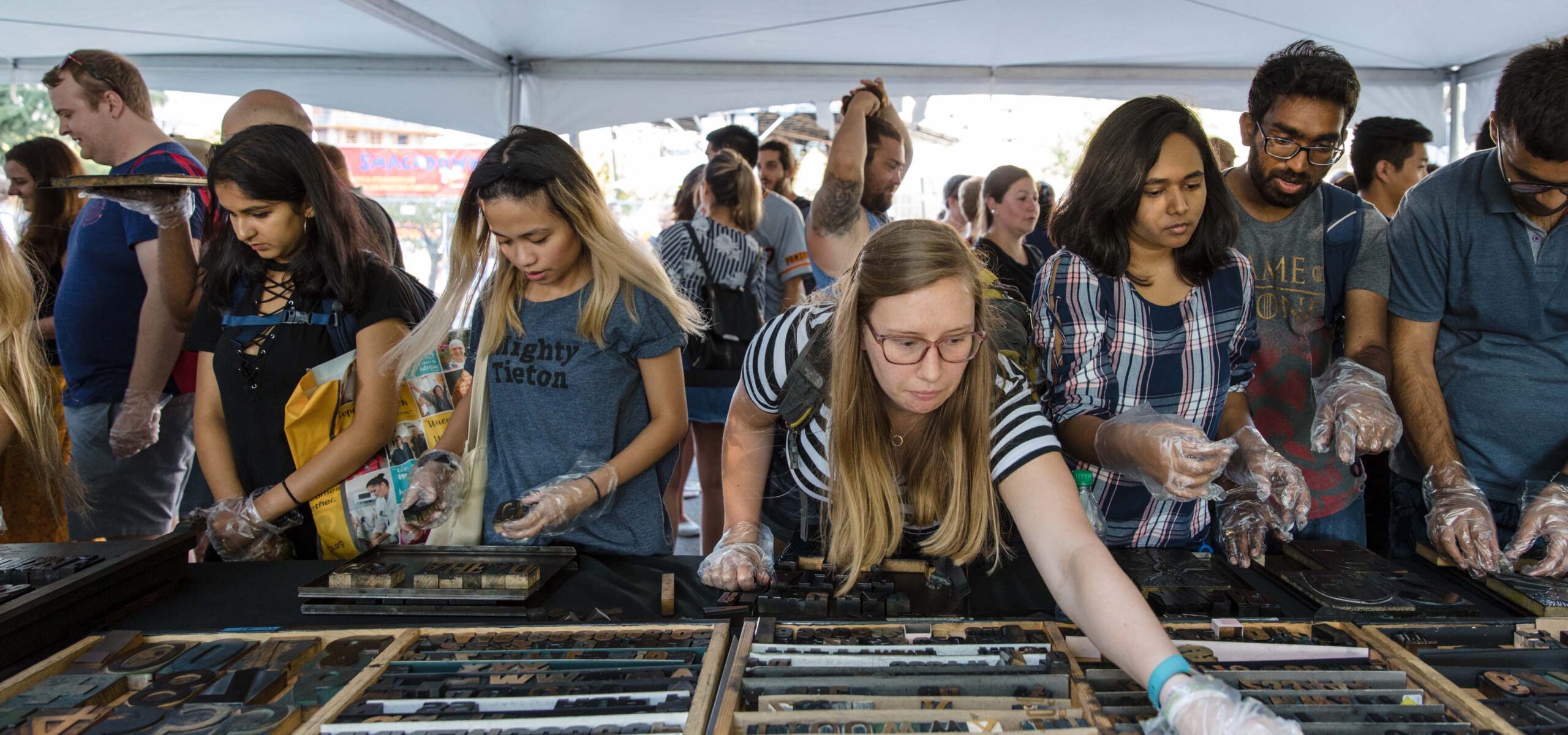 People selecting letterpress woodblocks for printing.