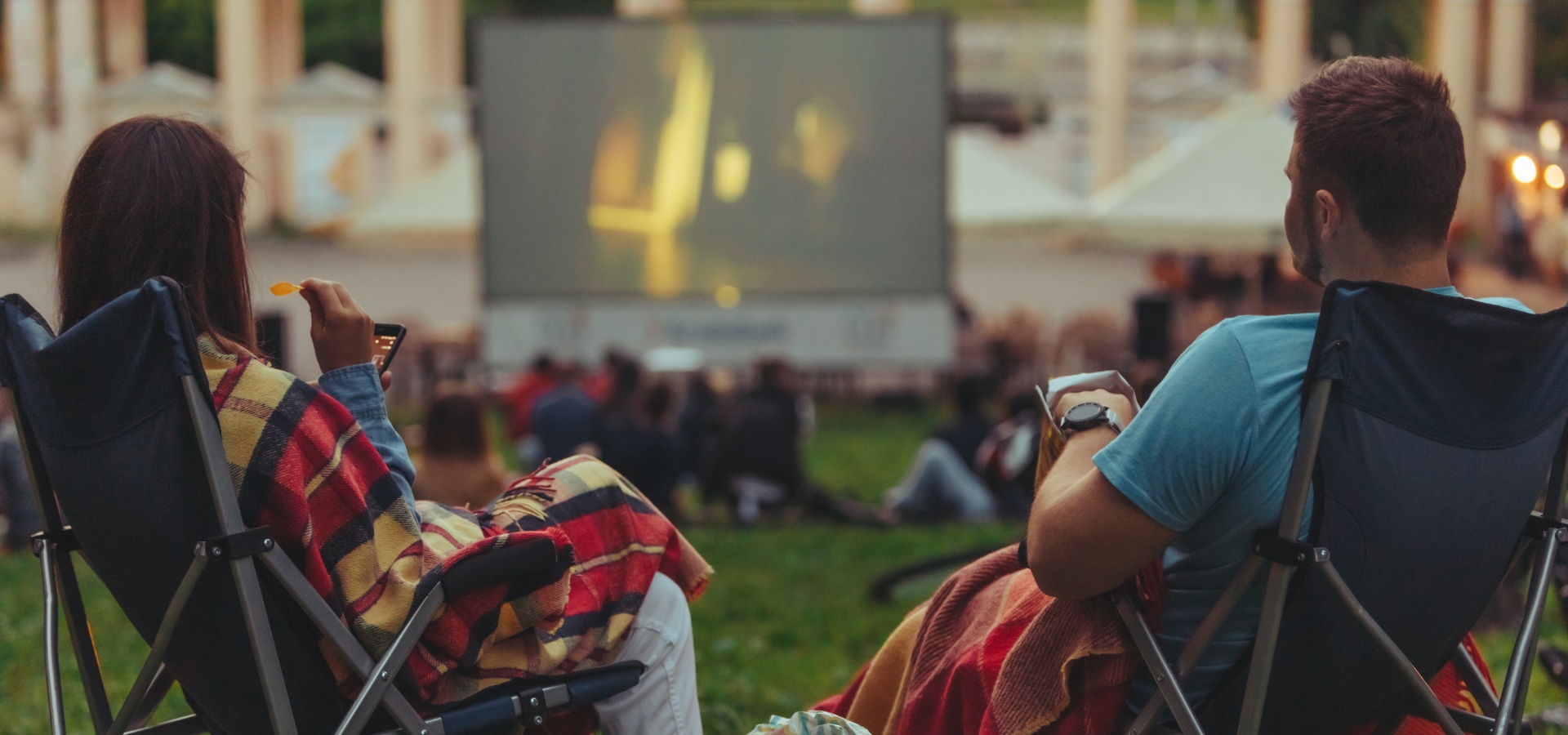 Two people watching an outdoor movie.