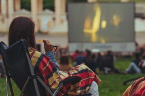 A woman watching an outdoor movie.