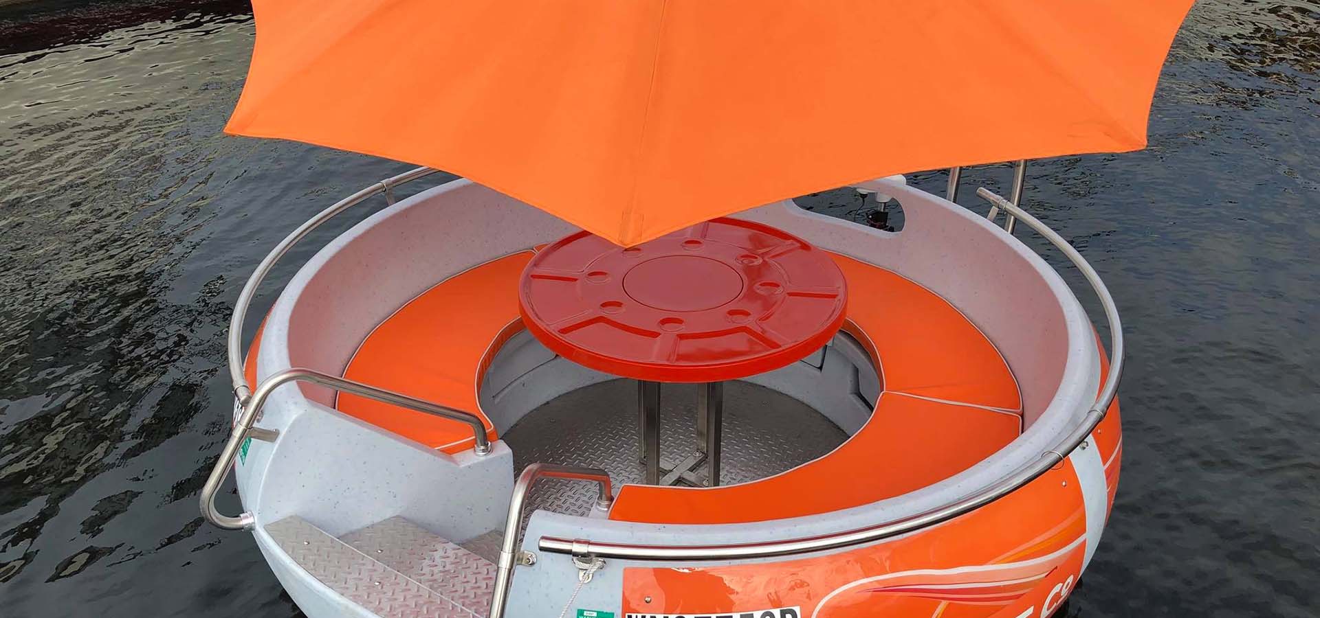 Mini boat shaped like a donut with orange umbrella