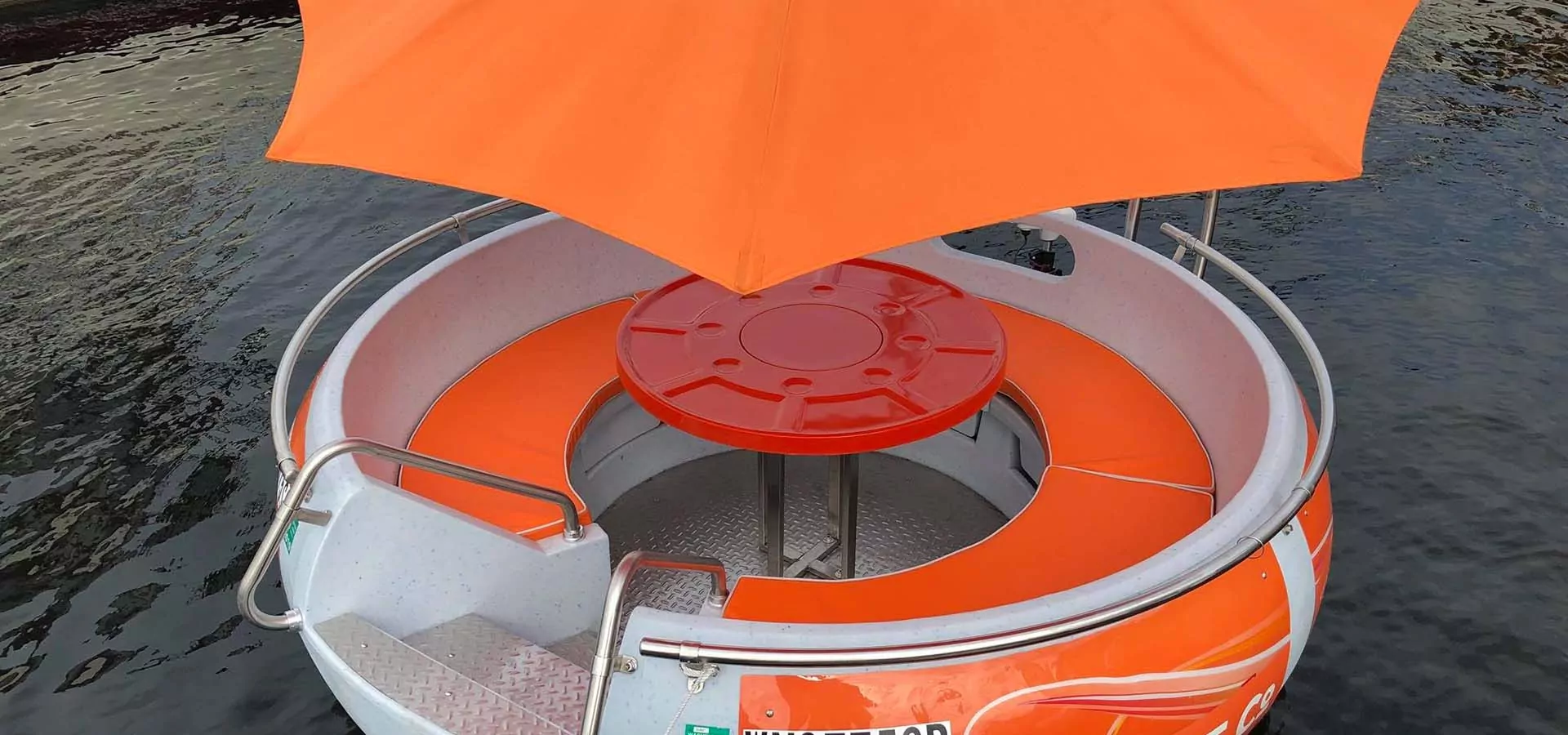 Mini boat shaped like a donut with orange umbrella