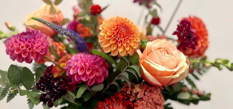 Bouquet of fall colored flowers in shades of pinks and oranges.