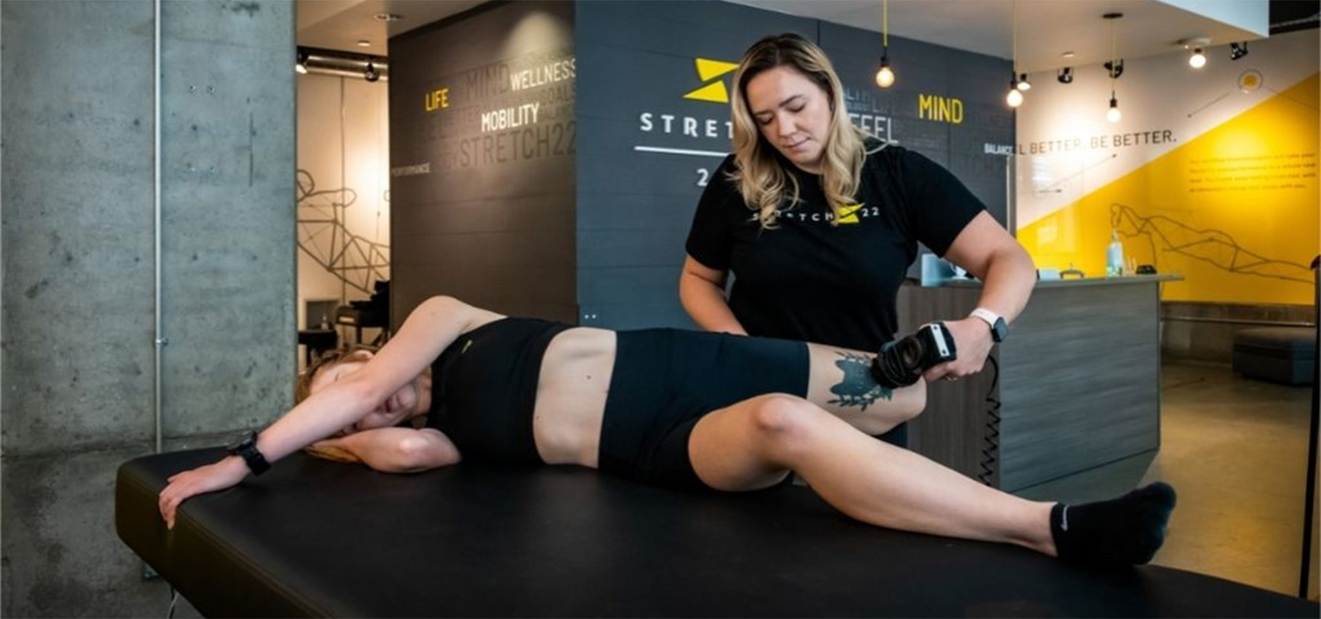 woman using theragun on patient