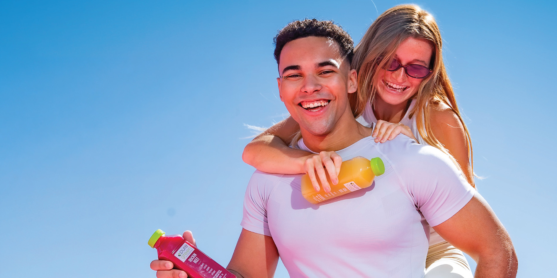 two people having fun and holding juice bottles
