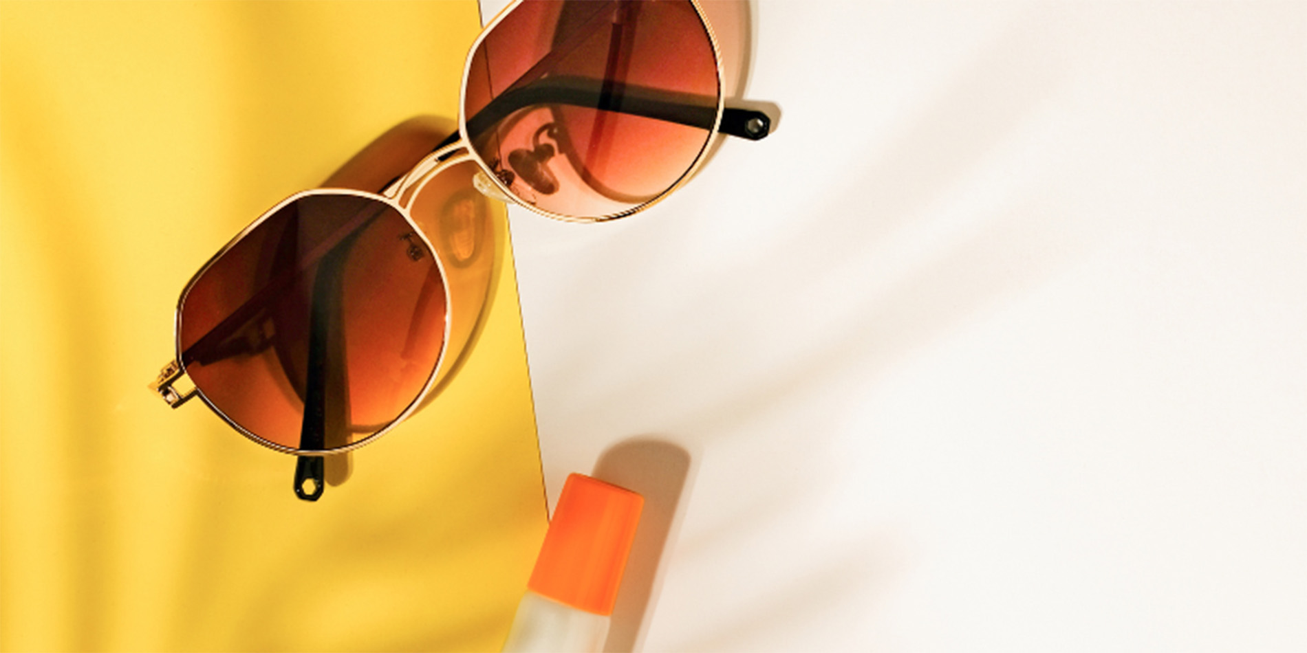 sunglasses and chapstick on yellow & white background