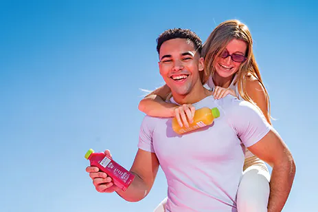two people having fun and holding juice bottles