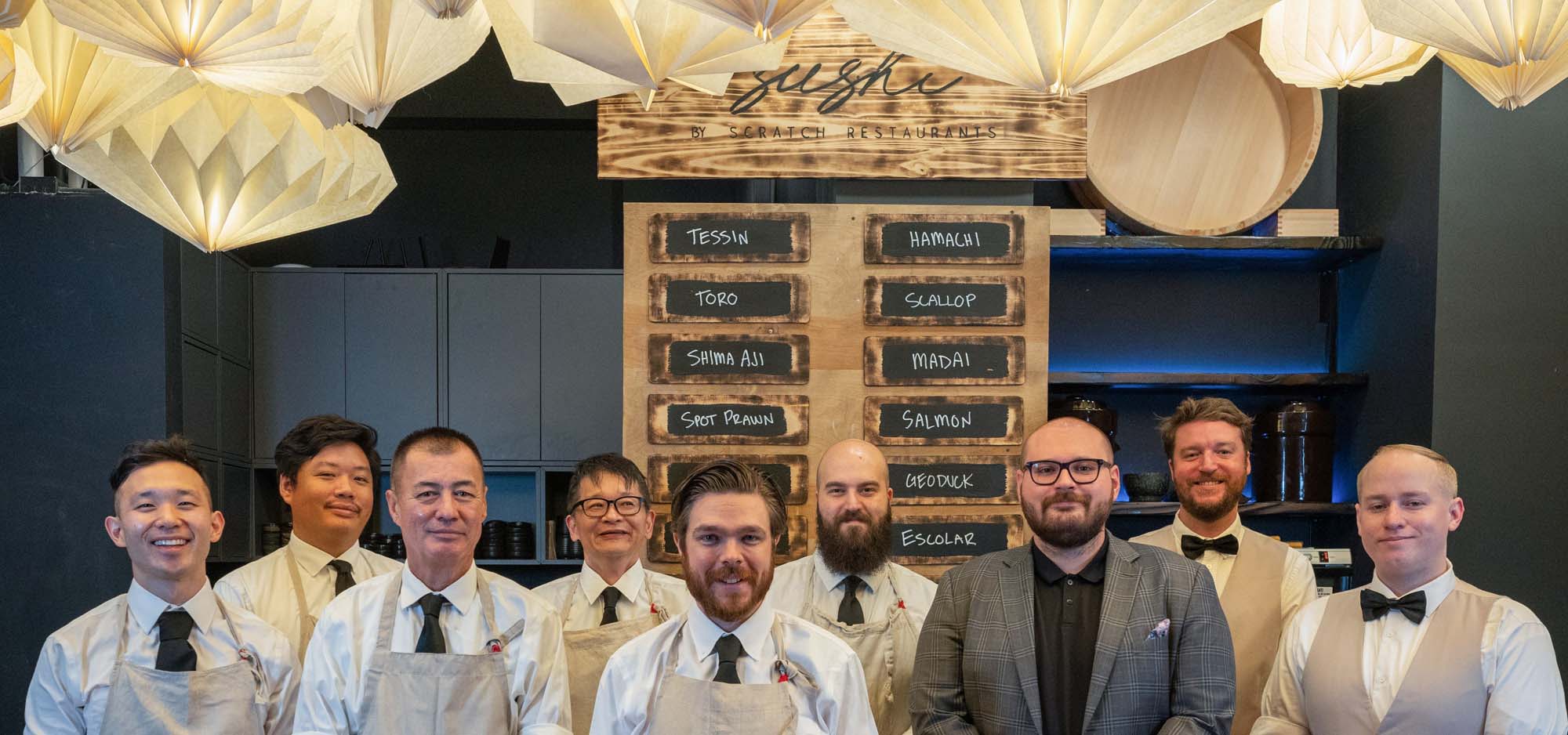 Group photo of sushi chefs in their kitchen.