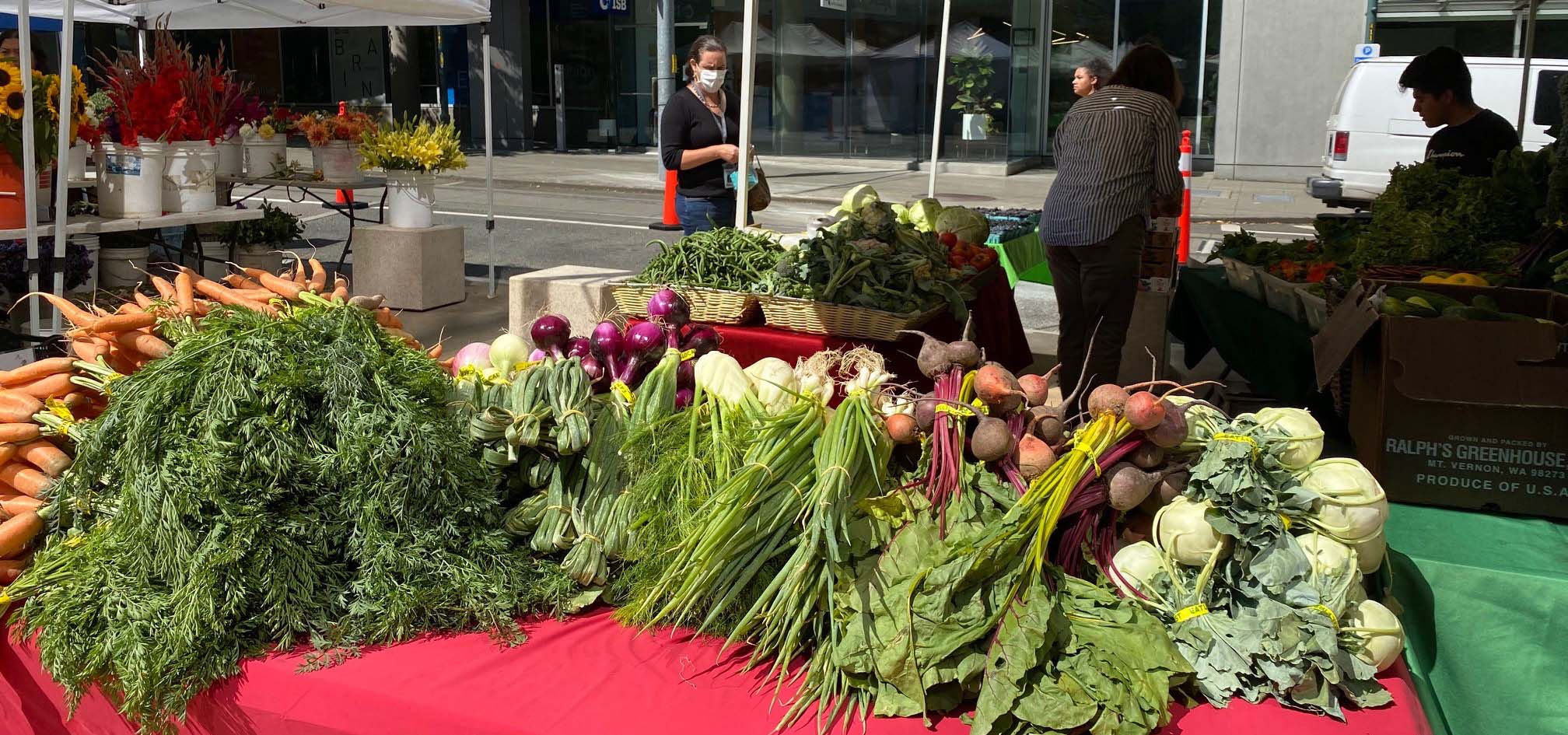 Table at a farmer's market filled with various vegetables.
