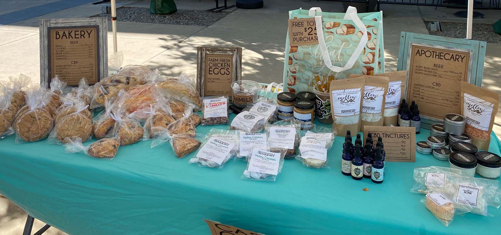 Table at a farmer's market filled with baked goods.