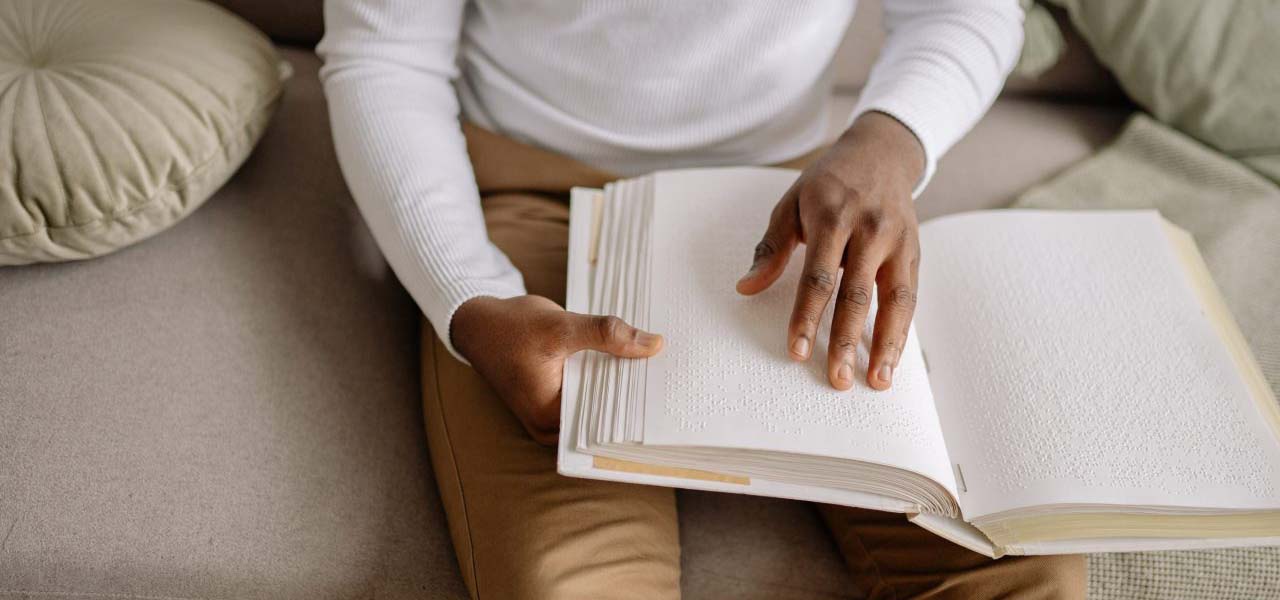 Man reading a book in braille.