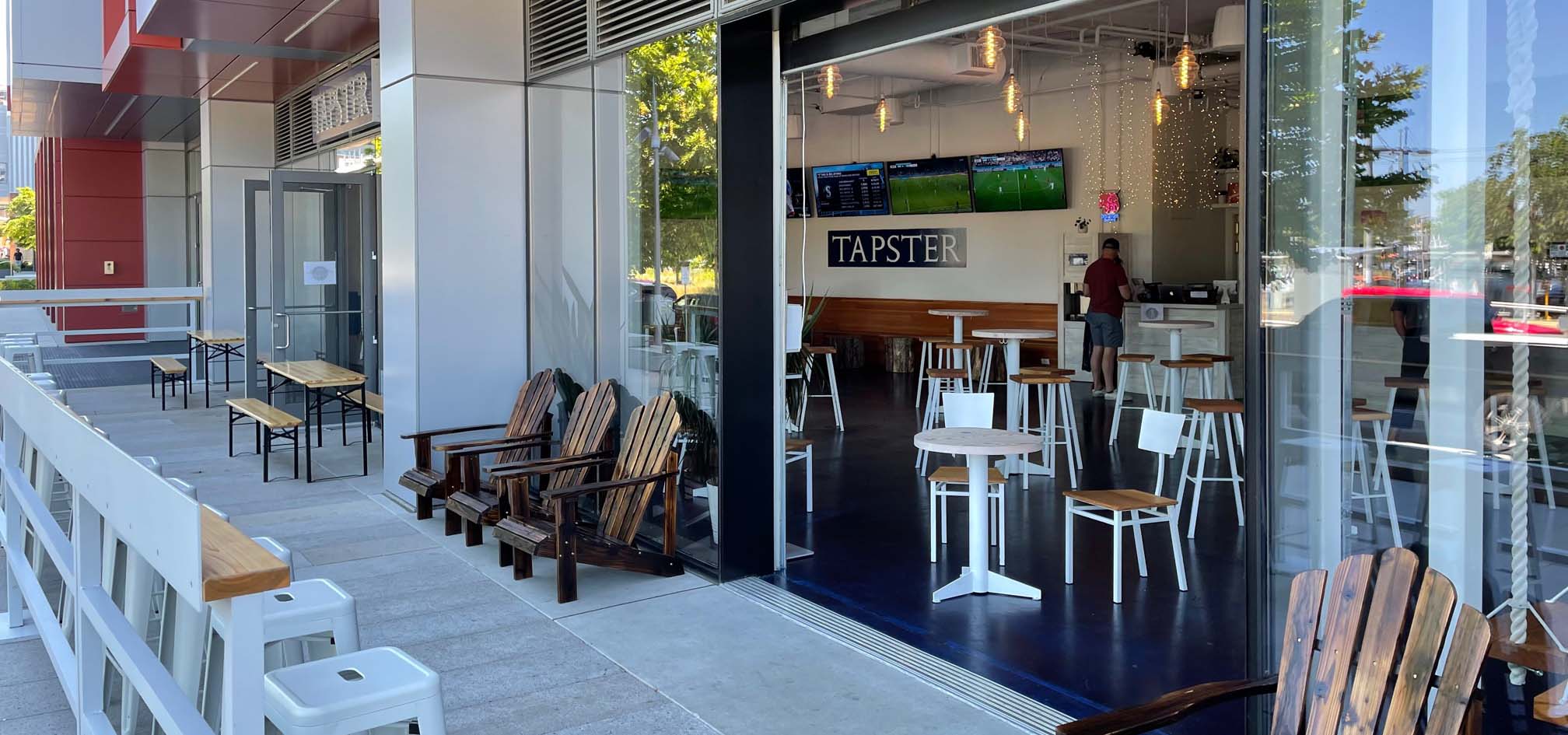 Taproom outdoor sidewalk patio with wood chairs.