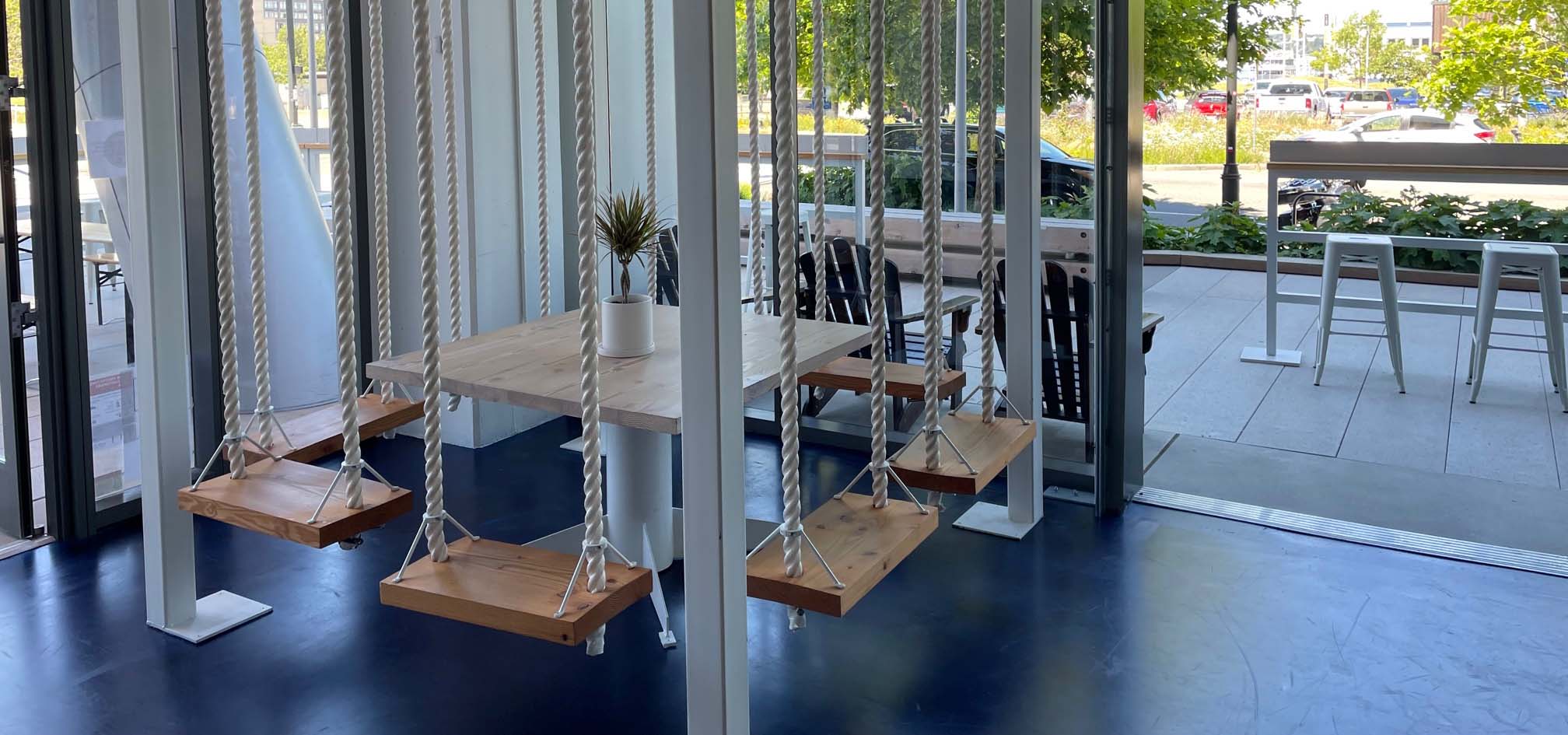 Treehouse swings inside a restaurant for fun patron seating.