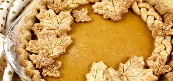 Fancy pumpkin pie with crust leaves.