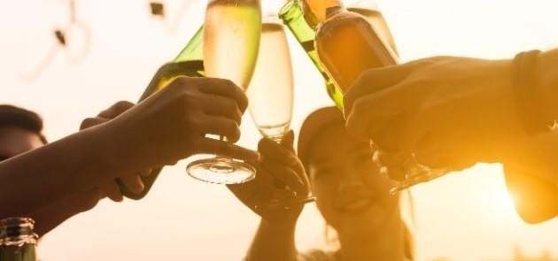 People making a toast during a sunset.