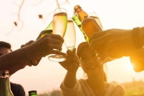 People making a toast during a sunset.